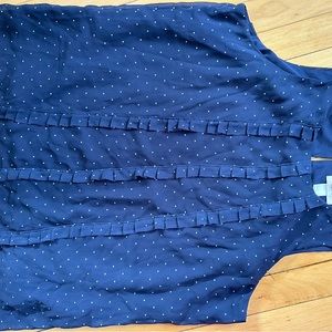 Navy with white polkadots and ruffles down the front.  Sleeveless. Size L